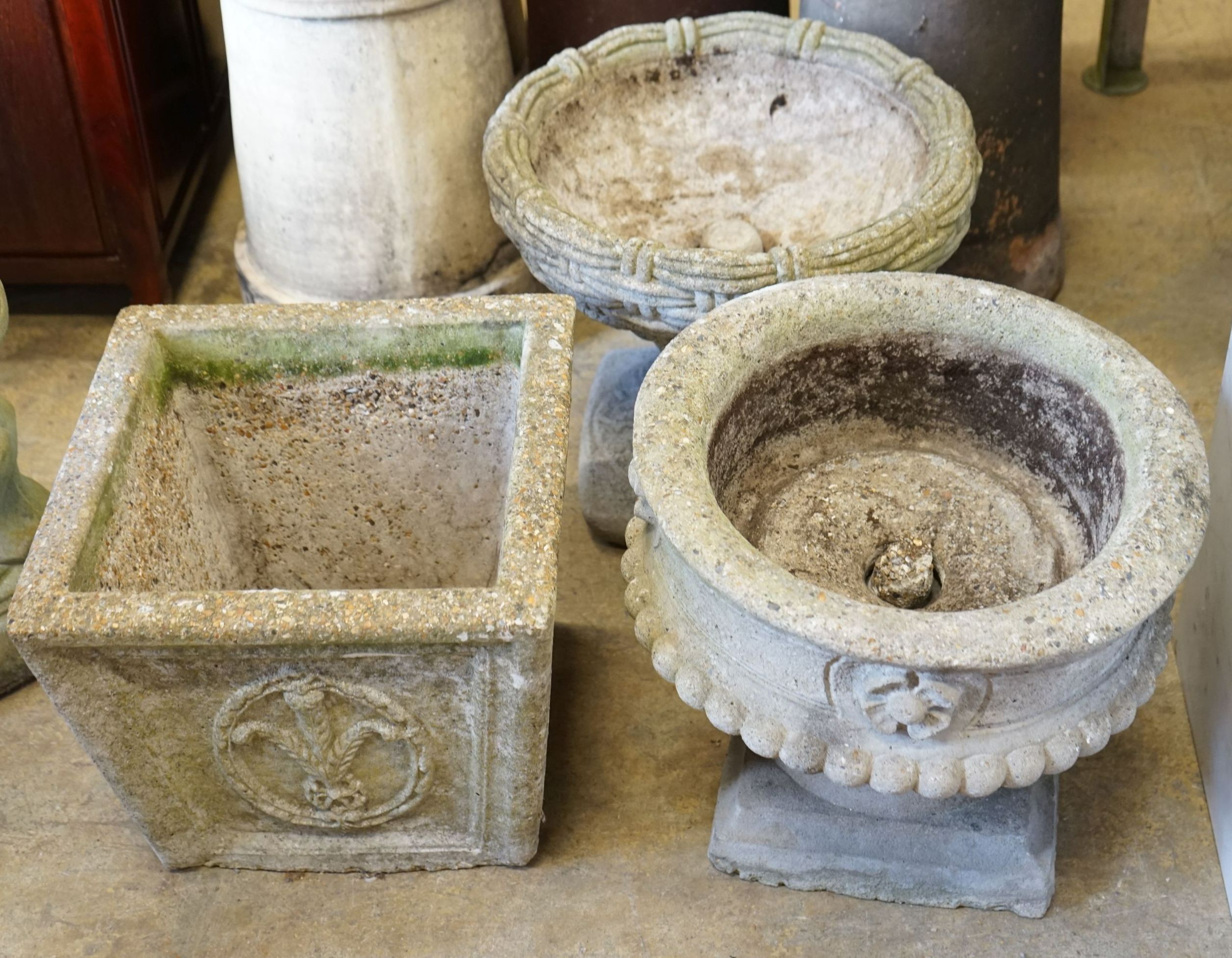 A group of three reconstituted stone garden planters, largest diameter 40cm, height 36cm